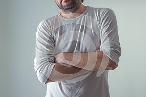 Casual ordinary man in blank white shirt standing, arms crossed photo