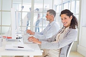 Casual pregnant businesswoman working at desk