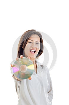 Casual smiling woman holding up compact disc or cd and looking