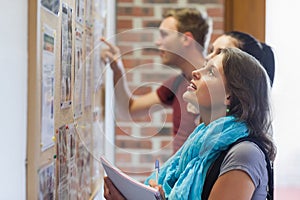 Casual students looking at notice board