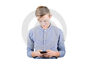 Casual teenager boy using his mobile phone to text someone isolated over white background. Adolescent guy communicate with his