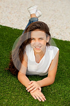 Casual teenager girl lying on the grass