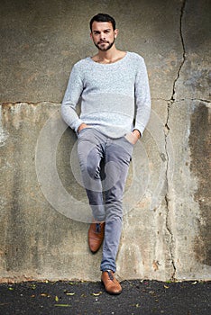 Casual urban style is his signature look. Shot of a handsome young man posing against an urban wall.