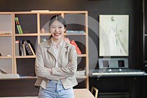 Casual woman with arms crossed at bright smiling office standing in front of her office.