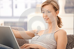 Casual woman browsing internet at home