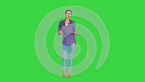 Casual woman in denim shirt dancing and looking at the camera on a Green Screen, Chroma Key.