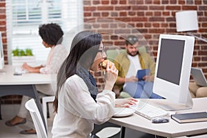 Casual woman drinking coffee while using computer