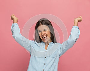 Casual woman feeling excited and raising her arms up