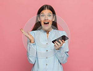 Casual woman feeling surprised after a message on her phone