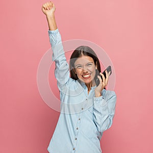Casual woman full of joy is celebrating the news