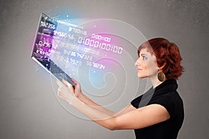 Casual woman holding laptop with exploding data and numers