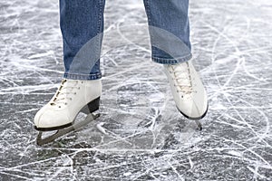 Casual woman look in ice skates and jeans on ice macro