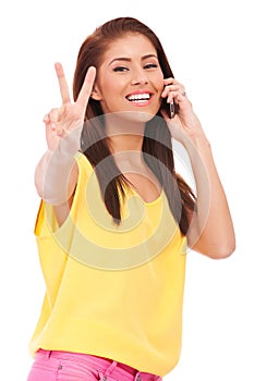 Casual woman with phone and victory gesture