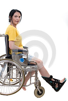 Casual woman in wheelchair with foot orthosis