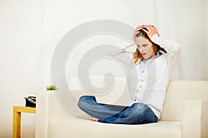 Casual woman working on sofa with a laptop