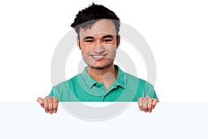 Casual young boy holding blank whiteboard