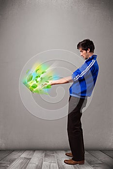 Casual boy holding laptop with recycle and environmental symbols