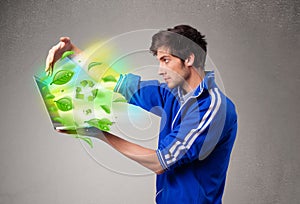 Casual boy holding laptop with recycle and environmental symbols