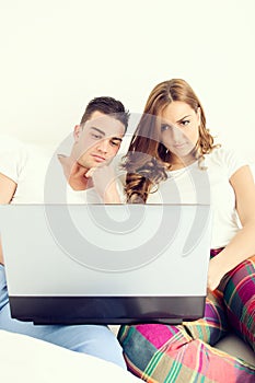 Casual young couple enjoying using laptop