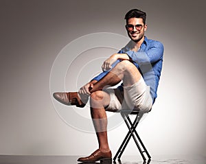 Casual young fashion man sitting with his legs crossed