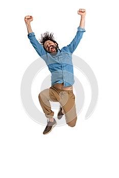 Casual young man celebrating success jumping in the air