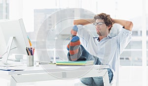 Casual young man with legs on desk in office