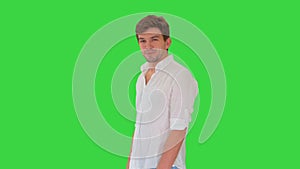 Casual young man looking at camera and talking about something on a Green Screen, Chroma Key.