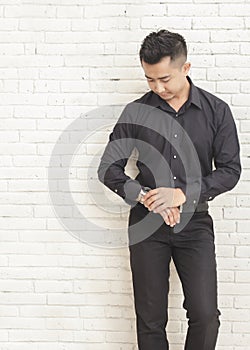 casual young man looking at his watches