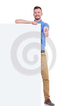 Casual young man with pannel shows thumb up