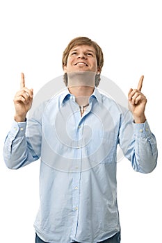 Casual young man pointing up