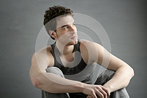 Casual young man portrait sit over gray