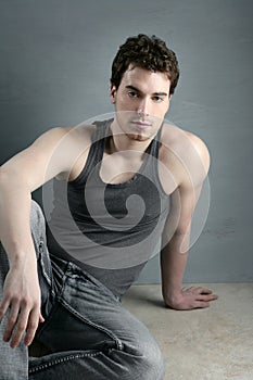 Casual young man portrait sit over gray