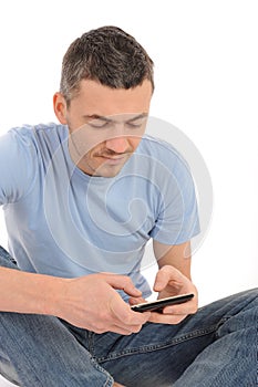 Casual young man sending sms on phone