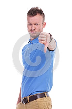 Casual young man shows thumb down