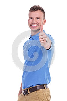 Casual young man shows thumb up