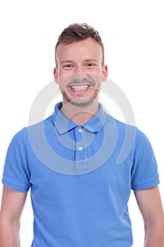 Casual young man smiles largely at you