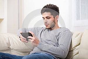 Casual young man using a tablet at home