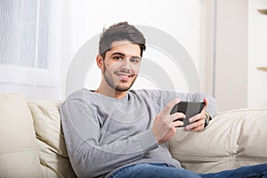 Casual young man using a tablet at home