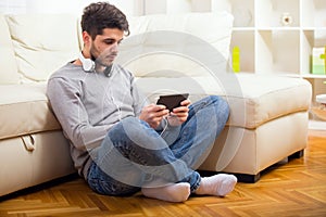 Casual young man using a tablet at home