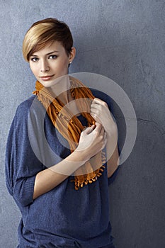 Casual young woman leaning to wall