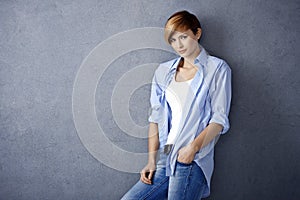 Casual young woman leaning to wall