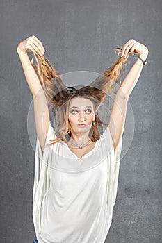 Casual young woman plaing with hair