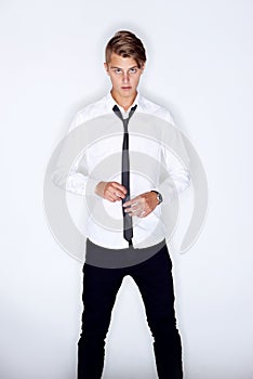 Casually cool. Portrait of a trendy young man standing against a white background.