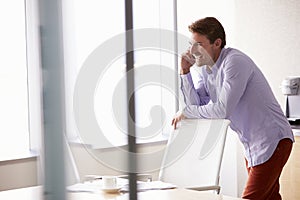 Casually Dressed Businessman Using Mobile Phone In Office