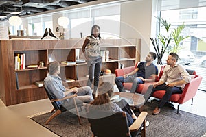 Casually Dressed Businessmen And Businesswomen Having Informal Meeting In Modern Office