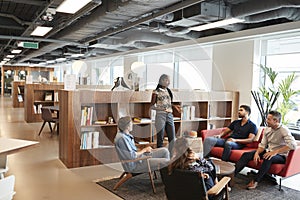 Casually Dressed Businessmen And Businesswomen Having Informal Meeting In Modern Office