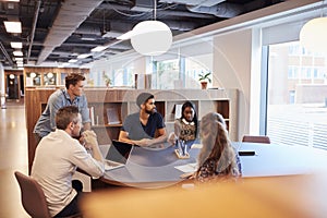 Casually Dressed Businessmen And Businesswomen Having Informal Meeting In Modern Office