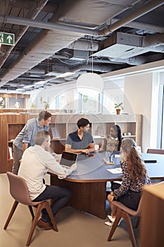 Casually Dressed Businessmen And Businesswomen Having Informal Meeting In Modern Office