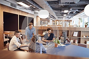 Casually Dressed Businessmen And Businesswomen Having Informal Meeting In Modern Office