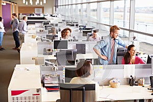 Casually dressed colleagues talking in an open plan office